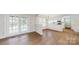 Bright eat-in kitchen with white cabinets, stainless appliances, wood floors, and adjacent pool view at 2605 Willowdale Ln, Matthews, NC 28105