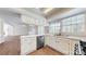 Kitchen view showcasing stainless appliances, white cabinets, a breakfast bar, and wood flooring at 2605 Willowdale Ln, Matthews, NC 28105