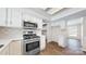 Bright open kitchen with white cabinetry, stainless steel appliances, and wood flooring at 2605 Willowdale Ln, Matthews, NC 28105