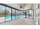 Screened-in porch overlooking a pool with a ceiling fan and wood plank flooring at 2605 Willowdale Ln, Matthews, NC 28105