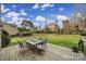 Spacious backyard with a wooden deck featuring an outdoor dining set, a well-manicured lawn and lush landscaping at 8908 Red Barone Pl, Waxhaw, NC 28173