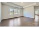 Spacious living room featuring a tray ceiling, hardwood flooring, and lots of natural light at 1603 Croydon St, Indian Land, SC 29707
