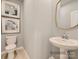 Stylish powder room with a pedestal sink and a modern mirror at 1808 Otter Perch Ln, Fort Mill, SC 29715