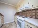 White appliances and patterned backsplash highlight this galley kitchen at 5315 Ruth Dr, Charlotte, NC 28215