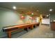 Basement game room features shuffleboard, pool table, and bar at 5839 Painted Fern Ct, Charlotte, NC 28269