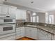 Kitchen features white cabinets, granite counters, and a breakfast bar at 5839 Painted Fern Ct, Charlotte, NC 28269