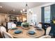 Dining room with round wood table, decorative chandelier, and view to the kitchen and living spaces at 7669 Tanglewood Way, Denver, NC 28037