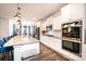 Modern kitchen with white cabinets, stainless steel appliances, large island, and hardwood floors at 7669 Tanglewood Way, Denver, NC 28037