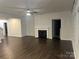 The spacious living room boasts a modern fireplace, ceiling fan, and dark laminate flooring at 7669 Tanglewood Way, Denver, NC 28037
