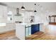 Kitchen features white cabinets, stainless steel appliances, an island, and hardwood flooring, creating a bright and modern space at 901 Edgemont Ave, Belmont, NC 28012