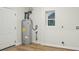 Basement features wood-look flooring, water heater, utility connections, and a window at 1423 Roseland Dr, Lincolnton, NC 28092