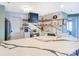 Bright, modern kitchen with a large marble island, stainless steel appliances, and open shelving for stylish storage at 18631 Vineyard Point Ln, Cornelius, NC 28031