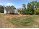 Exterior view of a home with a spacious backyard, bordered by lush trees at 5037 Faith Rd, Salisbury, NC 28146