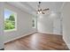 This bedroom features hardwood floors, a ceiling fan, and a large window overlooking a green lawn at 5037 Faith Rd, Salisbury, NC 28146