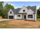Charming new construction home with white siding, a black roof, a two-car garage, and a manicured lawn at 5037 Faith Rd, Salisbury, NC 28146
