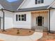 Charming home featuring a stylish black front door with a wooden portico and well-manicured landscaping at 5037 Faith Rd, Salisbury, NC 28146