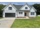 Charming two-story home featuring a black garage door, black framed windows, and a well-manicured lawn at 5037 Faith Rd, Salisbury, NC 28146