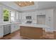 Kitchen boasts modern white cabinets, island, and stainless appliances, all under a wood ceiling at 5037 Faith Rd, Salisbury, NC 28146