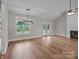Open living room features hardwood floors, a modern light fixture, and access to the deck through glass doors at 5037 Faith Rd, Salisbury, NC 28146