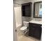 Bathroom with a dark vanity, framed mirror, and tiled shower-tub with shelf at 1826 Birch Heights Ct, Charlotte, NC 28213