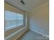 This is a vacant bedroom featuring a window with blinds and neutral-colored walls and carpet at 1826 Birch Heights Ct, Charlotte, NC 28213