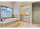 Elegant bathroom with tile flooring, a soaking tub, and a walk-in shower with updated shower head at 2425 Birdie Ne Ln, Conover, NC 28613