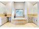 Inviting bathroom with a soaking tub surrounded by tile, separate vanities, and plenty of storage at 2425 Birdie Ne Ln, Conover, NC 28613