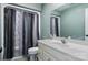 Bright bathroom featuring a vanity sink, mirror, toilet, and shower with decorative shower curtain at 2425 Birdie Ne Ln, Conover, NC 28613