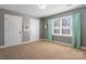 Carpeted bedroom with two closets, gray walls, and a bright window with aqua curtains at 2425 Birdie Ne Ln, Conover, NC 28613