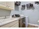 Well-lit laundry room featuring a stainless steel washer and dryer, utility sink and wire shelving at 2425 Birdie Ne Ln, Conover, NC 28613