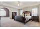 Well-lit main bedroom with a ceiling fan, tray ceilings, and an archway leading to another room at 2425 Birdie Ne Ln, Conover, NC 28613