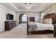 Spacious main bedroom with carpet, ceiling fan, and a large dark wood bed frame at 2425 Birdie Ne Ln, Conover, NC 28613