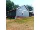 Green sided home featuring a brick foundation, lush lawn, and mature trees at 1589 Maysville Rd, Shelby, NC 28150