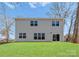 Back exterior of a two-story home with gray siding, a well-manicured lawn, and ample windows at 3110 Westerwood Dr, Charlotte, NC 28214