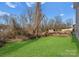 Green backyard featuring a large lawn and a shed, enclosed by a fence and trees at 3110 Westerwood Dr, Charlotte, NC 28214