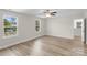 Large bedroom showcases wood-look floors, neutral walls, a ceiling fan, and natural light through two windows at 3110 Westerwood Dr, Charlotte, NC 28214