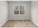 A bright bedroom features neutral walls, wood-look floors, and a large window overlooking a wooded area at 3110 Westerwood Dr, Charlotte, NC 28214