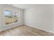 Bright, empty bedroom featuring hardwood floors, a large window, and neutral wall paint, ready for personalization at 3110 Westerwood Dr, Charlotte, NC 28214