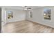 Spacious bedroom with wood-look flooring, neutral walls, a ceiling fan, and a view from three windows at 3110 Westerwood Dr, Charlotte, NC 28214