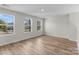 Spacious bedroom with three windows offering ample natural light and wood-look flooring at 3110 Westerwood Dr, Charlotte, NC 28214