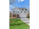 Charming two-story home with a well-manicured lawn, gray siding, and a brick front porch at 3110 Westerwood Dr, Charlotte, NC 28214