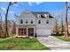 New construction home featuring gray siding, brick accents, an attached garage, and a well-manicured lawn at 3110 Westerwood Dr, Charlotte, NC 28214