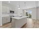 Modern kitchen featuring an island with a sink, stainless steel appliances, and bright lighting with outdoor view at 3110 Westerwood Dr, Charlotte, NC 28214
