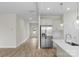Open kitchen with stainless steel appliances and view to the front door at 3110 Westerwood Dr, Charlotte, NC 28214