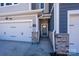 Close-up of a townhome entrance with a stylish front door, stone accents, and a well-lit walkway at 161 Halite Ln, Waxhaw, NC 28173