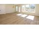Bright living room boasts wood-look floors, large windows, and modern light fixture at 161 Halite Ln, Waxhaw, NC 28173