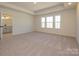 Spacious main bedroom features a tray ceiling, plush carpet, and large windows at 161 Halite Ln, Waxhaw, NC 28173