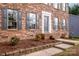 Brick house boasts a manicured lawn, garden, and a welcoming front entrance with dark shutters at 316 Reed Creek Rd, Mooresville, NC 28117