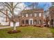 Traditional two-story brick home with a well-manicured lawn, mature tree, attached garage, and gray shutters at 316 Reed Creek Rd, Mooresville, NC 28117