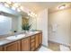 Double vanity bathroom with granite countertops and large mirror at 7534 April Mist Trl, Huntersville, NC 28078